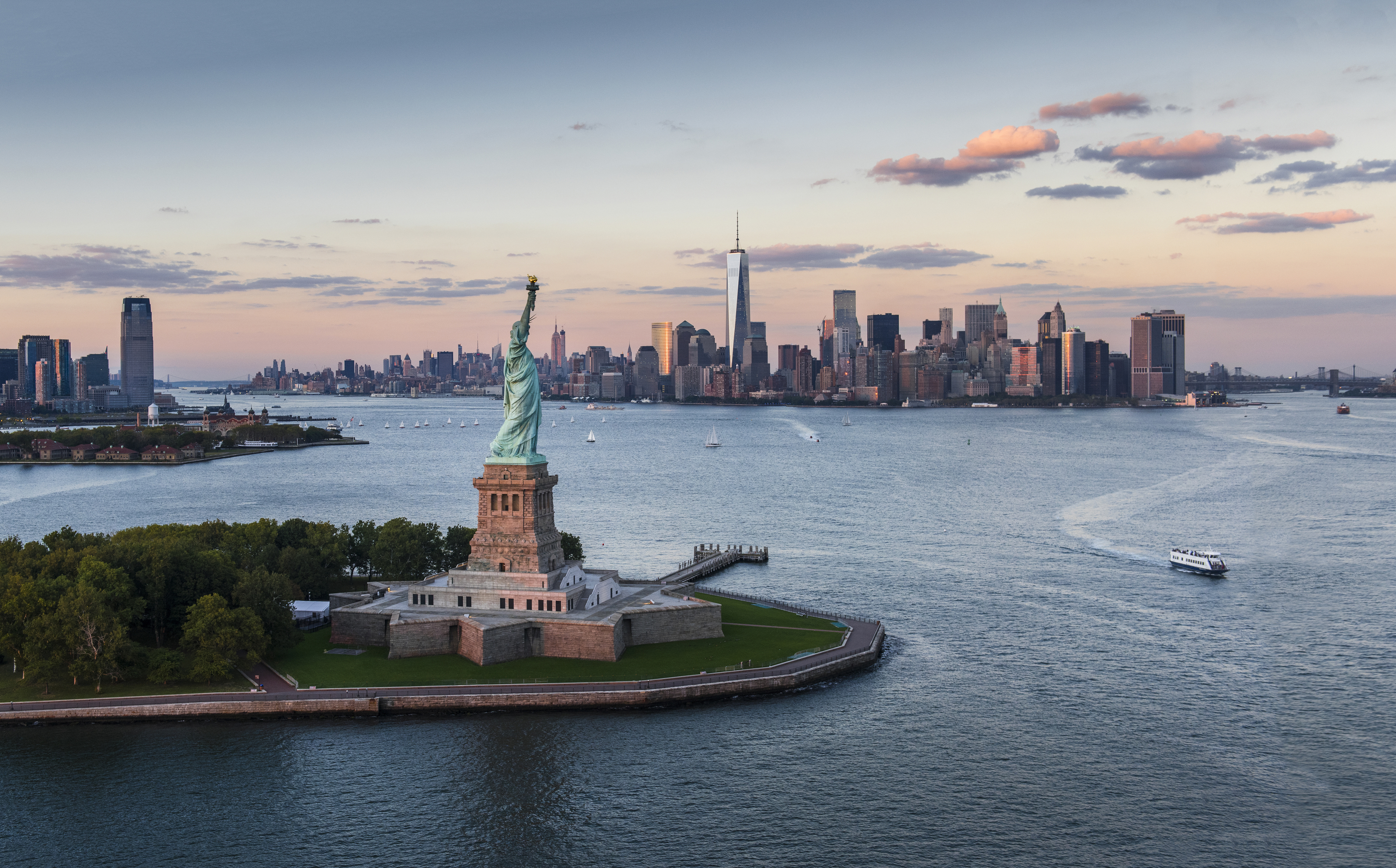 USA, New York State, New York City, Aerial view of city with Statue of Liberty at sunset
