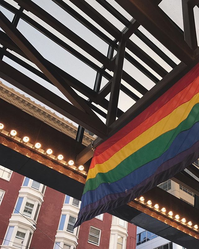 This is a photo of a rainbow flag hanging from a rooftop in San Francisco.