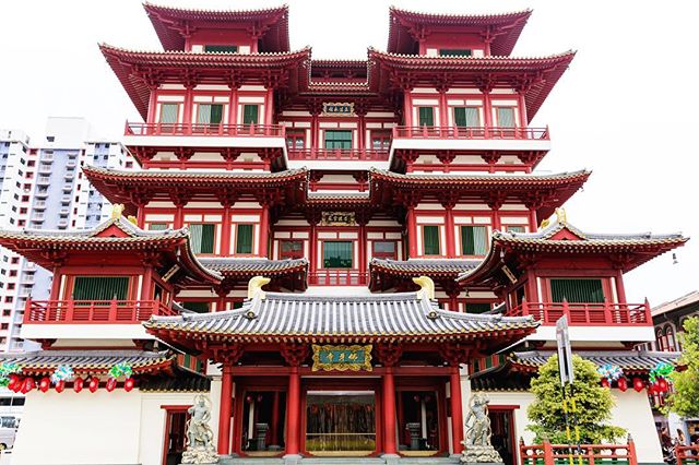This is a photo of a Buddhist temple. The temple is red and white and has many layers.
